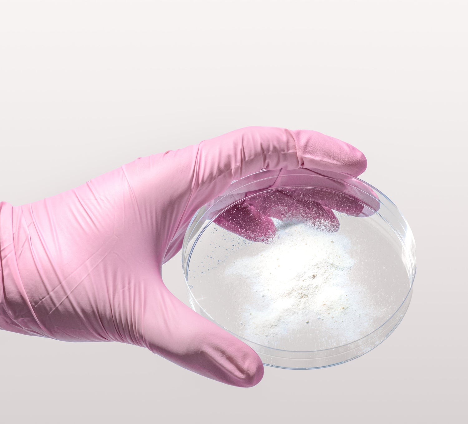 A gloved hand holds a petri dish with white powder, representing Happy V supplement ingredients.