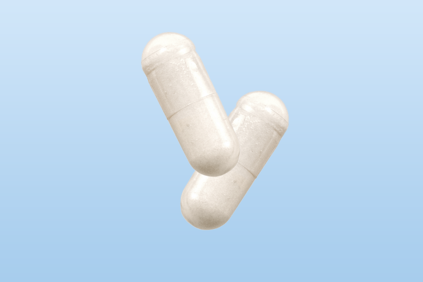 Two white Happy V supplement capsules on a light blue background, promoting women's wellness.