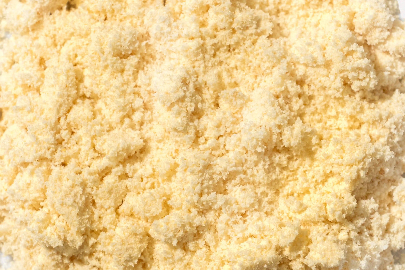 Fine yellow powder texture on a white background, representing Happy V supplement ingredients.