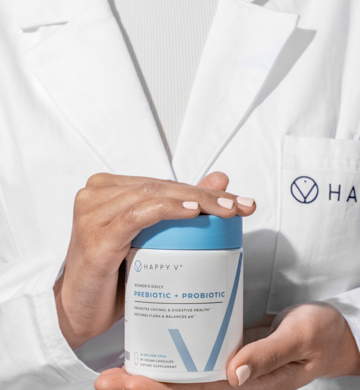 Happy V women's daily prebiotic and probiotic bottle held by a woman in a lab coat.